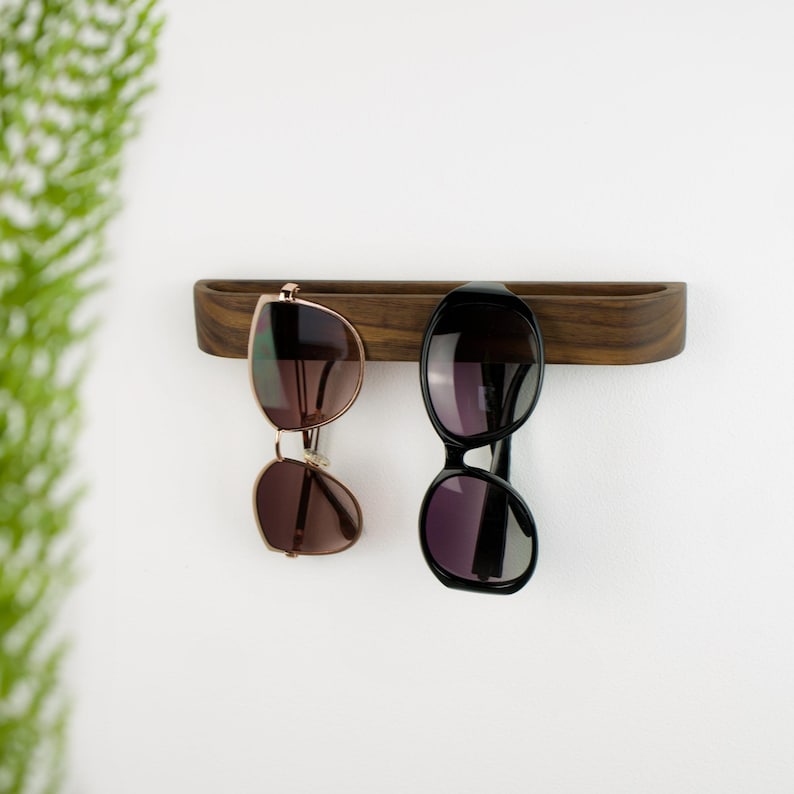 Self adhesive glasses hook crafted from solid walnut wood, modern wall mounted reading glasses holder, practical wooden organizer for keeping eyewear in one place at home or office