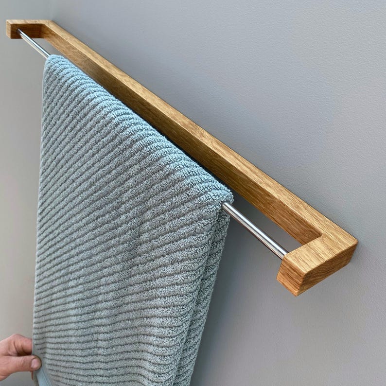 oak towel rack, wooden towel holder, wall mounted rack, minimalist wood hanger, Scandinavian design, modern bathroom decor, solid oak wood, handmade towel rack, eco-friendly bathroom, natural wood accessory, nordic home style, sleek wood rail, bathroom wall hook, functional wood decor, rustic modern rack, minimal bathroom storage, minimalist bathroom organizer, simple wood towel rail, wooden bathroom accessory, space-saving towel rack, zen bathroom decor, modern oak bathroom, clean design,