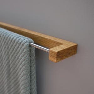 oak towel rack, wooden towel holder, wall mounted rack, minimalist wood hanger, Scandinavian design, modern bathroom decor, solid oak wood, handmade towel rack, eco-friendly bathroom, natural wood accessory, nordic home style, sleek wood rail, bathroom wall hook, functional wood decor, rustic modern rack, minimal bathroom storage, minimalist bathroom organizer, simple wood towel rail, wooden bathroom accessory, space-saving towel rack, zen bathroom decor, modern oak bathroom, clean design,