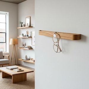 Minimalist self adhesive wooden glasses holder made from natural oak or American walnut wood, designed for modern interiors. This wall mounted reading glasses hook helps keep eyewear organized and always within reach in the office, bathroom or hallway. A practical, elegant and space saving wooden organizer with no drilling required.