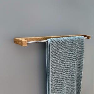 oak towel rack, wooden towel holder, wall mounted rack, minimalist wood hanger, Scandinavian design, modern bathroom decor, solid oak wood, handmade towel rack, eco-friendly bathroom, natural wood accessory, nordic home style, sleek wood rail, bathroom wall hook, functional wood decor, rustic modern rack, minimal bathroom storage, minimalist bathroom organizer, simple wood towel rail, wooden bathroom accessory, space-saving towel rack, zen bathroom decor, modern oak bathroom, clean design,