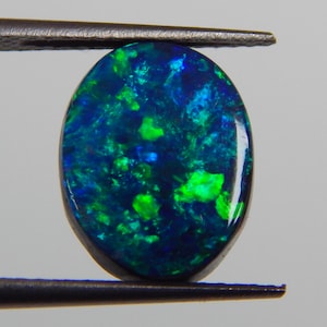 May include: A set of three ceramic mugs with a speckled, cream-coloured glaze. Each mug features a different hand-painted design: a blue and green leaf, a yellow flower, and a red berry. The mugs have a simple, modern design.