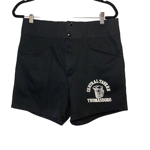 May include: Black shorts with two front pockets and a button closure. The shorts feature a white graphic of a beer mug and the words "CENTRAL TAVERN THOMASBORO" in a circular design.