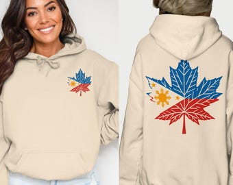 Peut inclure: Un sweat à capuche crème avec un grand motif de feuille d'érable. La feuille est divisée en deux, la moitié supérieure représentant le drapeau philippin et la moitié inférieure un motif rouge et blanc.