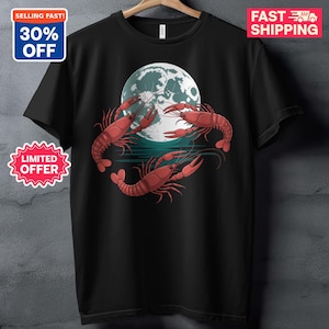 以下が含まれることがあります： 黒いTシャツ。3匹の赤いザリガニが水面上の満月を囲むグラフィック。Tシャツはグレーの壁に掛けられています。「SELLING FAST! 30% OFF」と「LIMITED OFFER」の文字が入っています。