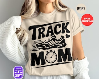 Könnte beinhalten: Ein beiges T-Shirt mit dem Text "Track Mom" in Schwarz. Der Text ist in einer fetten, stilisierten Schriftart. Eine Schwarzweißillustration eines Laufschuhs und einer Stoppuhr sind im Design enthalten.