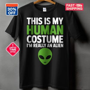 Pode incluir: Camiseta preta com o texto "THIS IS MY HUMAN COSTUME I'M REALLY AN ALIEN" em branco e verde. Um rosto alienígena verde está abaixo do texto. Inclui 30% de desconto e um selo de oferta por tempo limitado.