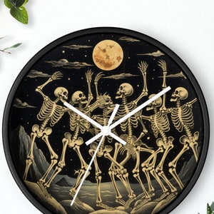May include: A black round wall clock with a white face and gold skeleton hands. The clock face features a black and gold illustration of five skeletons dancing around a full moon.