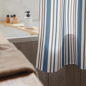 May include: A shower curtain with vertical stripes in white, brown, and blue. The curtain is hanging in a bathroom, with a wooden bath tray holding bath products. A white soap dispenser is also visible.