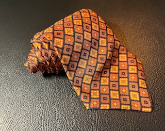 May include: A brown silk tie with a geometric pattern of orange and black squares.