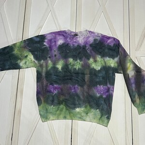 This adult Large Gildan crewneck is tie dyed with a water color effect.  These are colors of green, purple, and black.