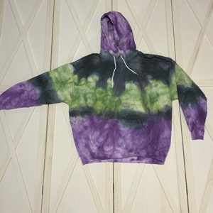 This XL adult Gildan hoodie is tie dyed with a water color effect.  These are colors of green, purple, and black.