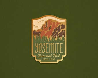 以下が含まれることがあります： 山脈、木々、そして「Yosemite National Park ESTD 1890」という文字が書かれたヴィンテージデザインの金色のエナメルピンです。