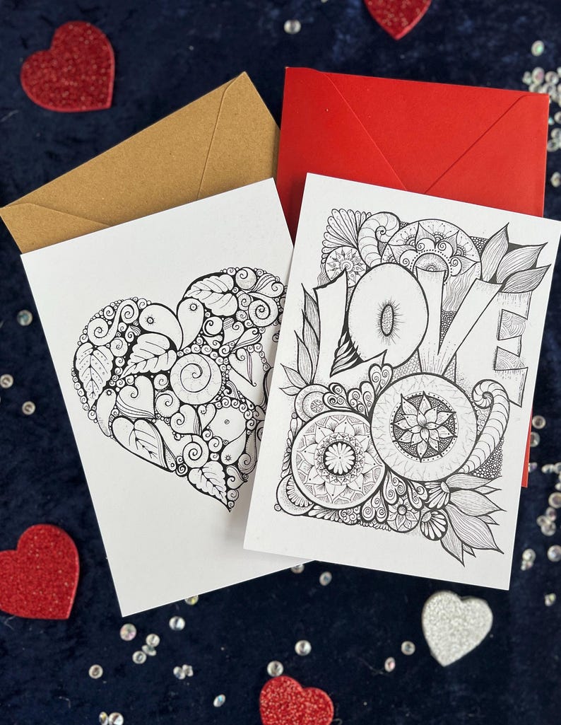 2 Love Postkarten selbst gemalt mit zentangle und Mandala Muster zum Ausmalen. Zwei Briefumschläge in rot und braun liegen im Hintergrund. Herz Deko drumherum