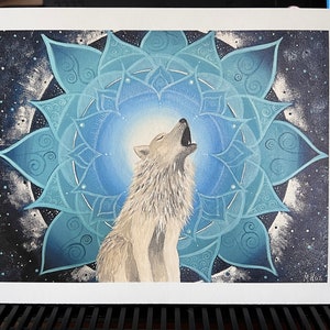 Kunstdruck vom Wolf Krafttier Bild mit einem Mandala. Der weiße Wolf heult bzw. ruft grade. Um ihn herum ist ein Mandala in blauen Tönen mit einem silbernen Ring außen herum. Das Bild wurde gemalt von der Künstlerin Miriam Linda Weiss