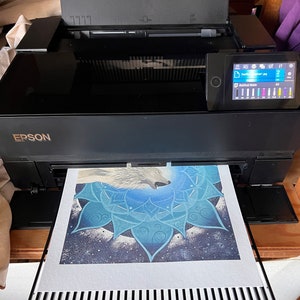 Kunstdruck vom Wolf Krafttier Bild wird grade mit dem Epson FineArt Drucker gedruckt. Im Papier-Ausgabefach liegt das gedruckte Wolf Bild