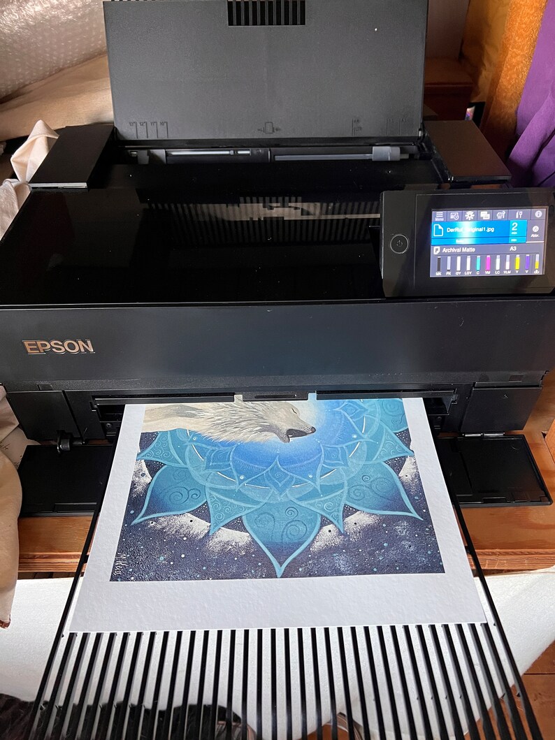 Kunstdruck vom Wolf Krafttier Bild wird grade mit dem Epson FineArt Drucker gedruckt. Im Papier-Ausgabefach liegt das gedruckte Wolf Bild