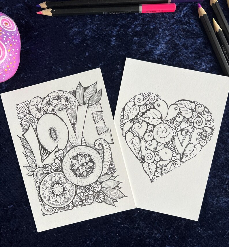 2 Love Postkarten selbst gemalt mit zentangle und Mandala Muster zum Ausmalen. Bleistifte und ein angemalter Stein liegen zur Deko drum herum