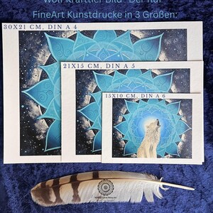 Wolf Krafttier Bild "Der Ruf". Gicleé Druck. Zu sehen ist ein weißer Wolf, der ruft, umgeben von einem Mandala in blau-Tönen. Die Kunstdrucke gibt es in drei Größen und diese sind auf dem Bild vermerkt. Vor den Bildern liegt eine Eulenfeder. Das Original Bild wurde gemalt von der Künstlerin Miriam Linda Weiss.