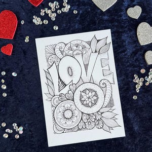 Handgezeichnete Love Postkarte zum Ausmalen mit Mandala- und floralen Mustern auf dunklem Stoff dekoriert mit Herz Deko