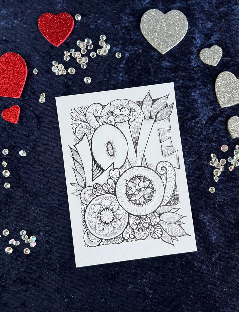 Handgezeichnete Love Postkarte zum Ausmalen mit Mandala- und floralen Mustern auf dunklem Stoff dekoriert mit Herz Deko
