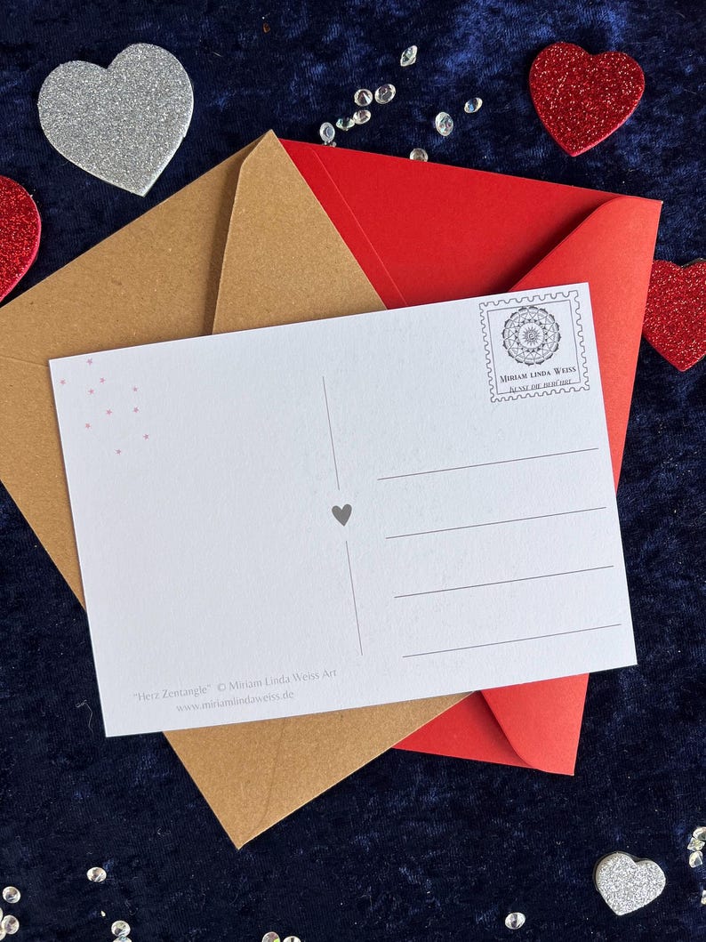 Rückseite der Herz Postkarte zum Ausmalen. Im Hintergrund liegen zwei Briefumschläge in braun und rot und Deko