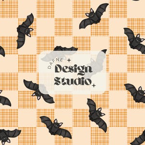 May include: A repeating pattern featuring black bats on a light orange and cream plaid background. The bats have white faces and are spread across the design. The text "DAFNE + Design Studio +" is in a white rectangle.