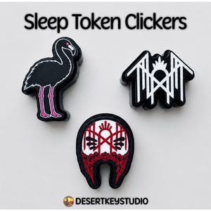 May include: Three black Sleep Token Clickers with white and red graphic designs. One features a flamingo, one a geometric white logo, and one a red and white circular emblem. The text Sleep Token Clickers and DESERTKEYSTUDIO are visible.