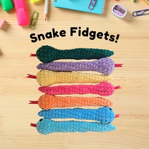 May include: A stack of seven colourful crocheted snake fidget toys. The snakes are green, purple, yellow, pink, orange, blue and light blue.