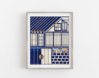 May include: Art print depicting a building facade with a blue roof and white walls. The artwork uses a repeating pattern of lines and shapes in blue, yellow, red, and white. The print is framed in a light wood frame.