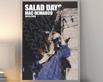 Op de afbeelding: Een zwart-wit poster met de tekst "Salad Days Mac Demarco 04/01/2014" bovenaan. De poster toont een foto van een persoon die een gitaar vasthoudt voor een bakstenen muur.
