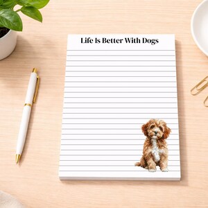 May include: A lined notepad with the text "Life Is Better With Dogs" at the top. A watercolor illustration of a brown and white puppy is at the bottom right. A white pen and a small plant are on the left.
