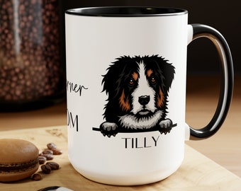 May include: White ceramic mug with a black rim and handle. The mug features a cartoon Bernese Mountain Dog peeking over the rim with the text "My Furry Mom" and the name "TILLY" underneath.