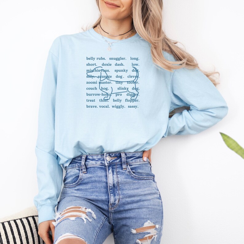 monochromatic design on comfort colors 
long sleeve tshirt with a word collage featuring an outline of a dachshund in background