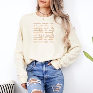 monochromatic design on comfort colors 
long sleeve tshirt with a word collage featuring an outline of a dachshund in background