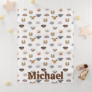 May include: A white baby blanket with a repeating pattern of colorful cartoon dog faces. The blanket has the name "Michael" printed in brown letters at the bottom.