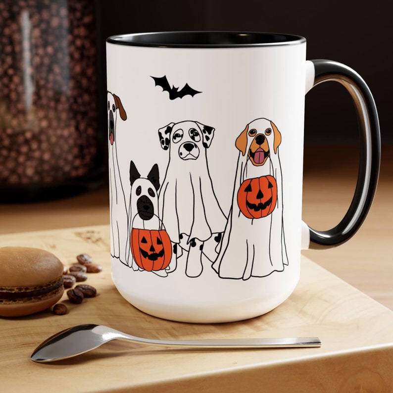 halloween ghost dog mug with a row of dogs in ghost costumes some carrying pumpkins and two black bats above them black interior and black handle 15 oz ceramic mug