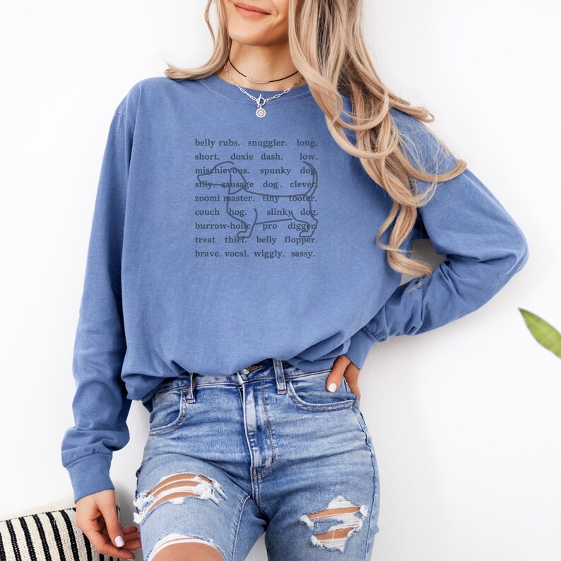 monochromatic design on comfort colors 
long sleeve tshirt with a word collage featuring an outline of a dachshund in background