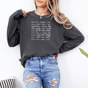 monochromatic design on comfort colors 
long sleeve tshirt with a word collage featuring an outline of a dachshund in background