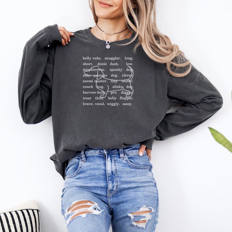 monochromatic design on comfort colors 
long sleeve tshirt with a word collage featuring an outline of a dachshund in background