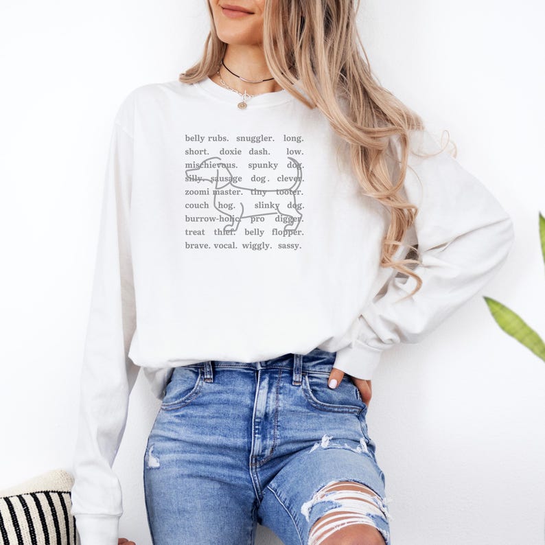 monochromatic design on comfort colors 
long sleeve tshirt with a word collage featuring an outline of a dachshund in background