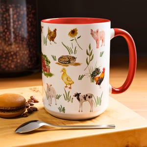 May include: White ceramic mug with a red rim and handle. The mug features a whimsical farm scene with a variety of animals, including a pig, a rooster, a cat, a duck, and a chicken. The animals are surrounded by green grass and flowers.