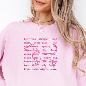 monochromatic design on comfort colors 
long sleeve tshirt with a word collage featuring an outline of a dachshund in background