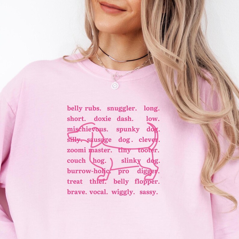 monochromatic design on comfort colors 
long sleeve tshirt with a word collage featuring an outline of a dachshund in background