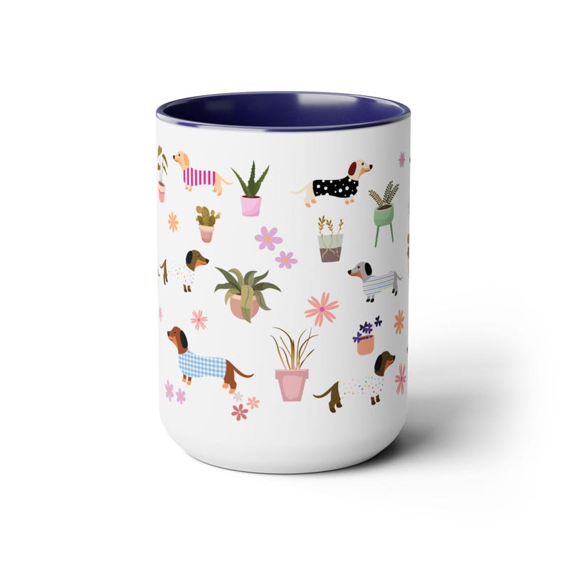 May include: White ceramic mug with a blue rim featuring a repeating pattern of dachshunds wearing pajamas and potted plants. The dachshunds are brown, black, and white.