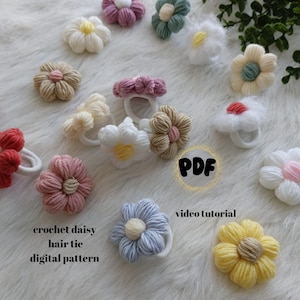 May include: A collection of crocheted daisy hair ties in various colors, including pink, white, yellow, blue, and green. The hair ties are arranged on a white fuzzy surface. The text "crochet daisy hair tie digital pattern" and "PDF video tutorial" is visible in the image.