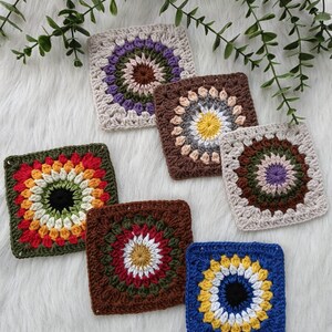 May include: Six crocheted granny squares with different color combinations. The squares feature a circular design with a central flower motif. The colors include red, orange, yellow, green, blue, brown, white, black, purple, and gray.
