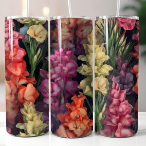 May include: Three stainless steel tumblers with a floral design. The tumblers feature a variety of flowers in shades of pink, yellow, orange, and purple on a black background.