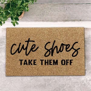 May include: A brown doormat with the text "cute shoes take them off" in black lettering.