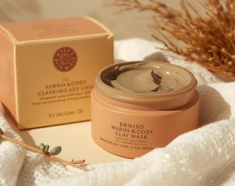 May include: A round peach-colored jar of clay mask with a matching box. The jar contains a smooth, light brown clay substance. The box and jar feature black text including the words BRNISD WARDS & COZY CLAY MASK and 5.1 Oz Cusk Oil.